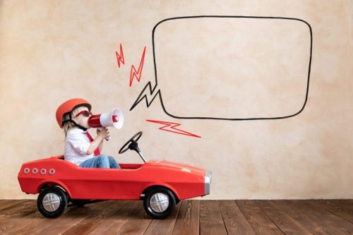 Funny kid driving toy car at home